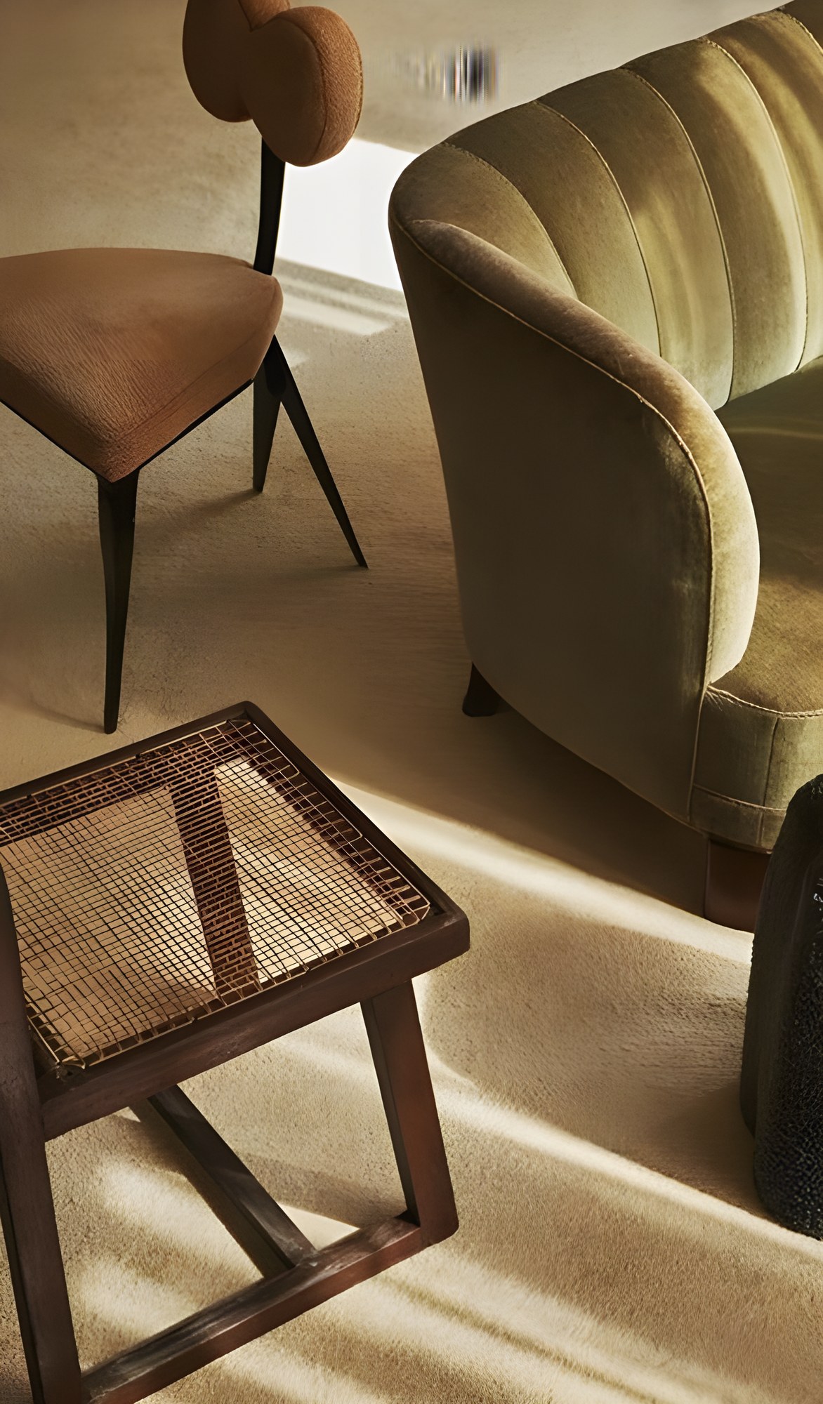 Fauteuil en velours et tabouret canné dans la lumière