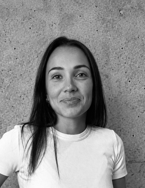 Portrait d’Ophélie Silva Ribeiro, architecte d’intérieur, devant un mur de béton
