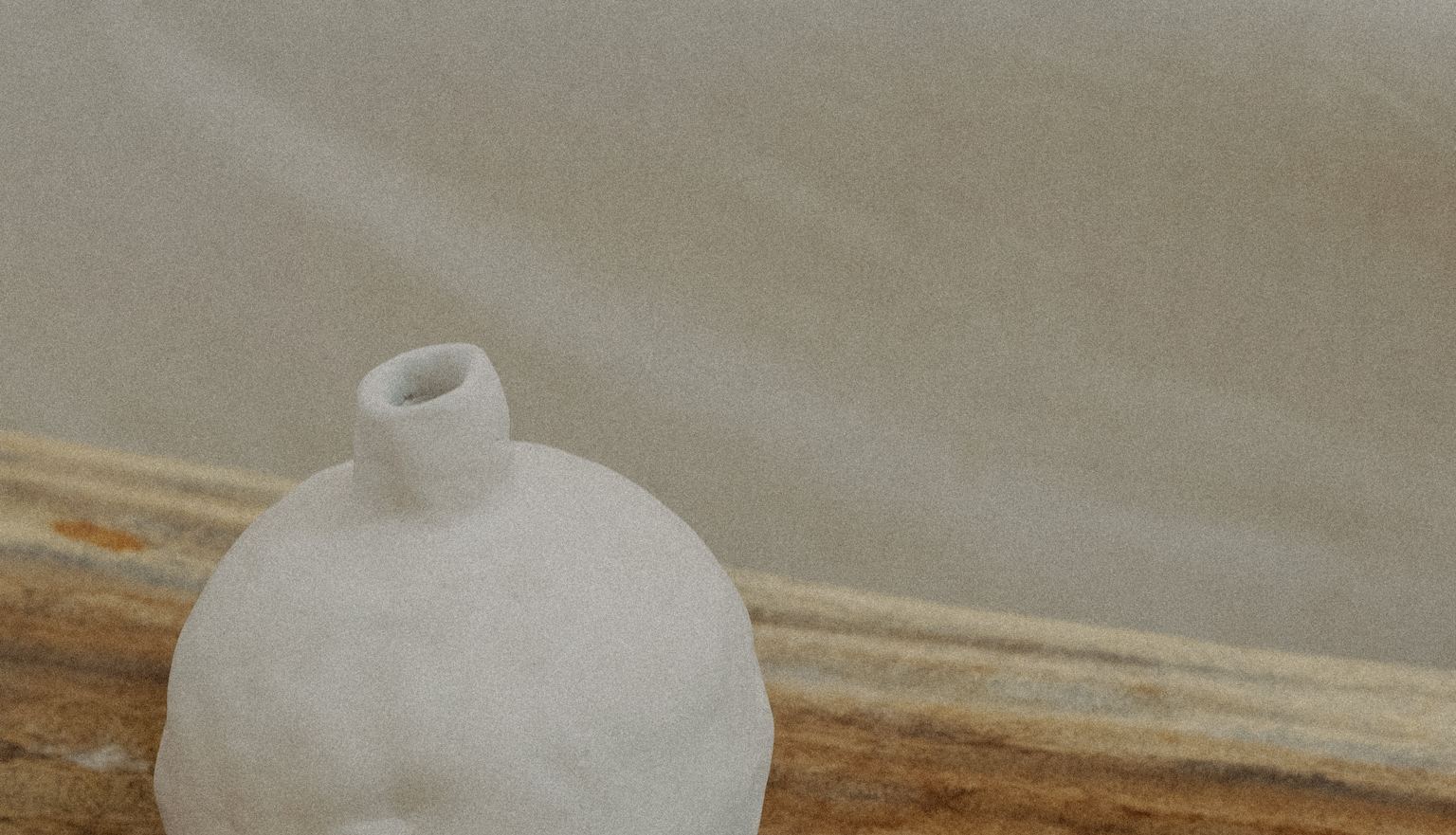 Vase en céramique blanche posé sur une tablette en pierre